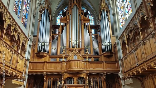 Grand wooden organ in a historic church with stained glass windows and ornate architecture
