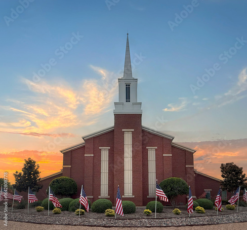 Mormon church at beautiful sunset. In front of the church American flags displayed in honor of Independence Day.