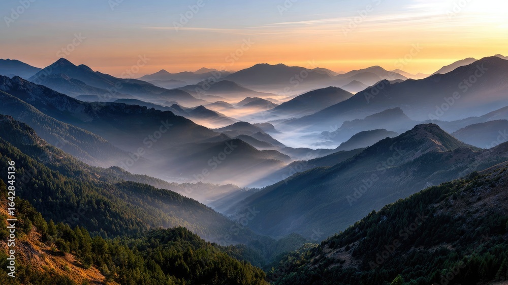 Obraz premium Mountain Serenity: A breathtaking vista unfolds, showcasing a mesmerizing layers of misty mountain ranges under a dawn sky, embodying the tranquil essence of natural grandeur.