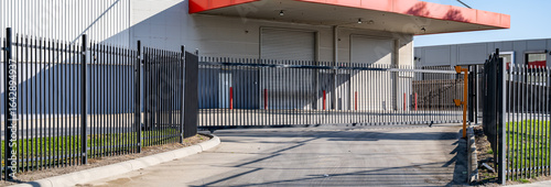 Canvastavla Secure industrial facility entrance with metal security fencing and an automated