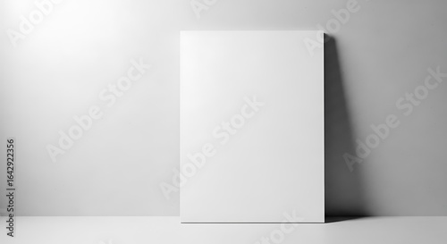 Fototapeta Naklejka Na Ścianę i Meble -  Blank white paper leaning against a wall, isolated on white background
