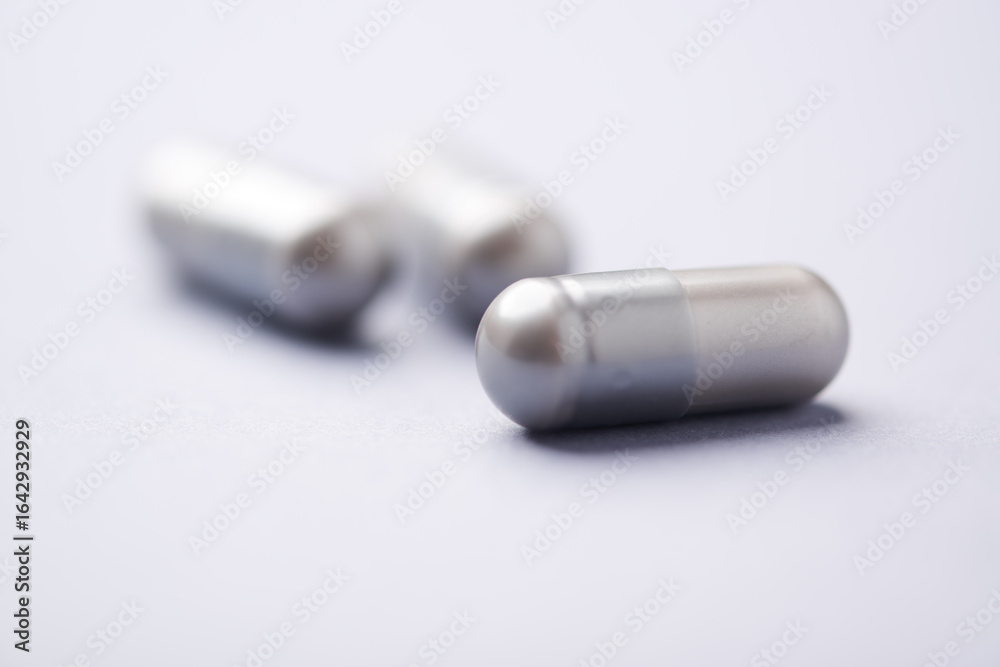 Naklejka premium Amino acids capsules on bright background. Soft focus. Close up. Copy space. 