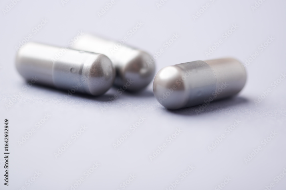 Naklejka premium Amino acids capsules on bright background. Soft focus. Close up. Copy space. 