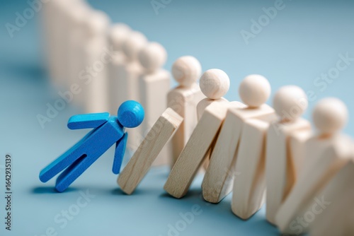 Blue figure topples dominoes of people