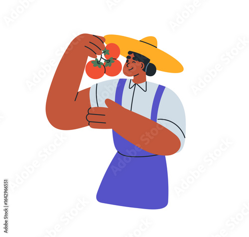 Female farmer holding tomato, fresh harvest. Happy woman in straw hat smellin...