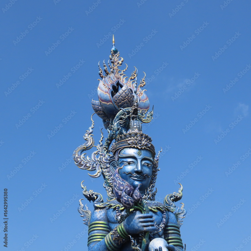 Fototapeta premium Wat Rong Suea Ten,Ornate architecture, Buddha and figures in the Blue Temple in Chiang Rai, Thailand, Asia