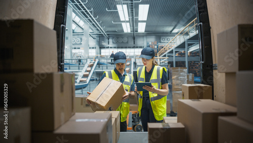 Fotografie Caucasian Female Stocking Associate Using Tablet Computer To Check Inventory In Logistics Facility With Conveyor Belt