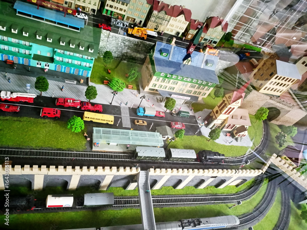 Obraz premium Artificially created toy mini-copy of the railway station and adjacent residential buildings and a transport interchange of a small European city.