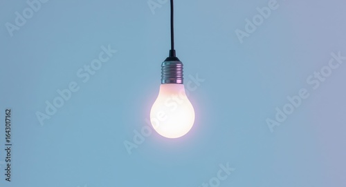 A Bright Idea. Lit Light Bulb on a Pale Blue Gradient Background, Simple and Clean