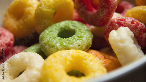 Colorful ultra processed food cereal rings in bowl showing vibrant texture and joyful breakfast mood for children and adults alike