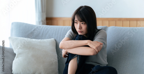 Foto リビングのソファに座る女性