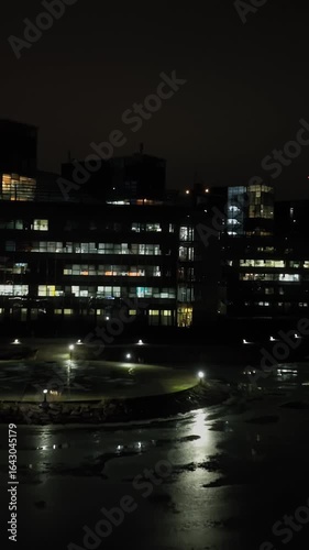 Wallpaper Mural Vertical drone shot approaching illuminated corporate buildings, winter night Torontodigital.ca