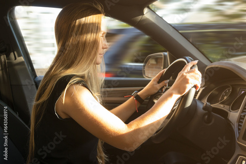Canvas-taulu Woman driving a car on a city street