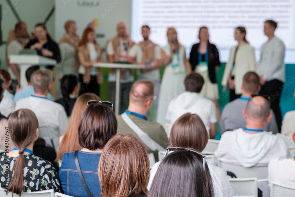 Obraz premium Conference attendees focus on speakers at podium, network at an engaging business seminar.