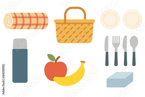 Picnic setup with a blanket, basket, fruits, and utensils for an outdoor gathering