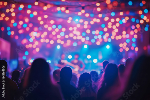 Silhouetted figures watch a live band perform at a concert