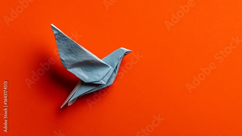 Wallpaper Mural Blue origami bird on vibrant orange background showcasing intricate folding artistry Torontodigital.ca