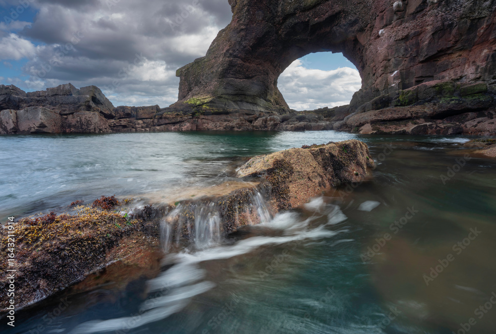 Obraz premium Auchmithie rock arch located on the Angus coastline of Scotland.