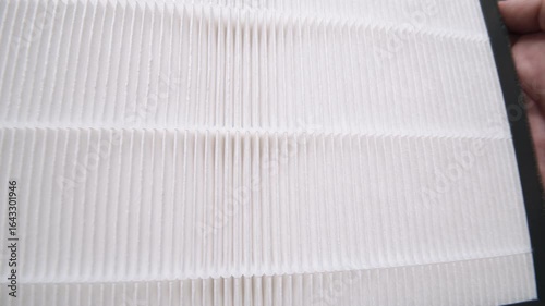 Hands rotate pleated air filter in close-up shot to show grip and texture for product interaction demo.