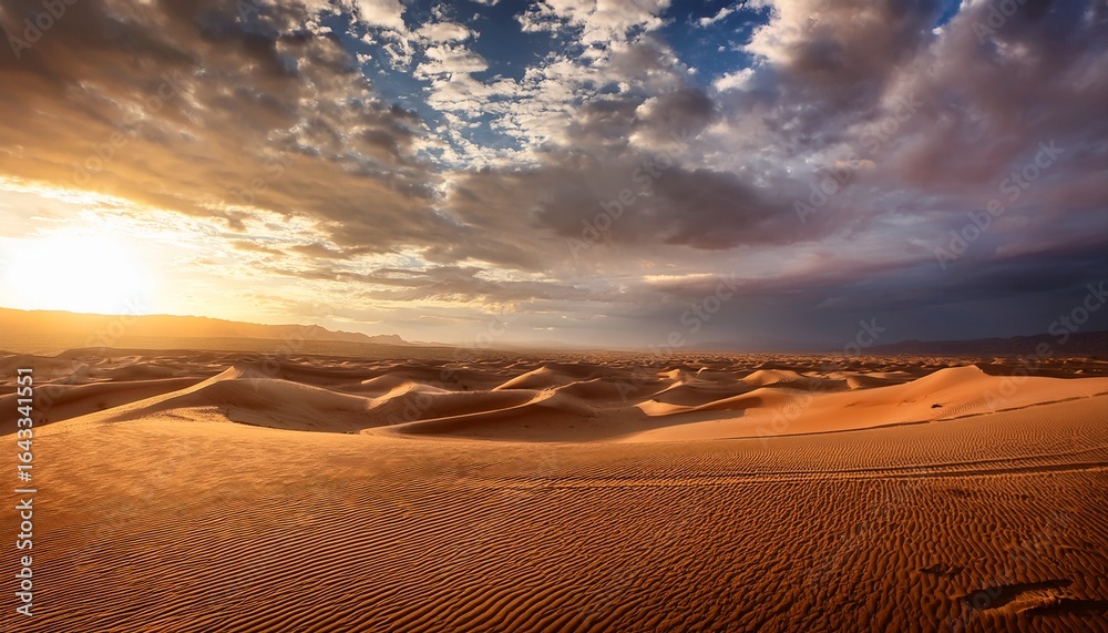 Naklejka premium dramatic landscape of a windswept desert under a moody sky with rolling clouds and warm sunlight