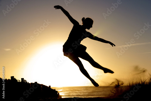 Wallpaper Mural Beautiful girl dancing at sunset on the beach Torontodigital.ca