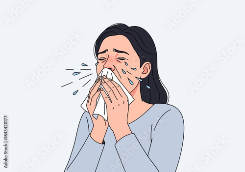 A young woman with a cold, flu, or allergies sneezes forcefully into a tissue, looking unwell.
