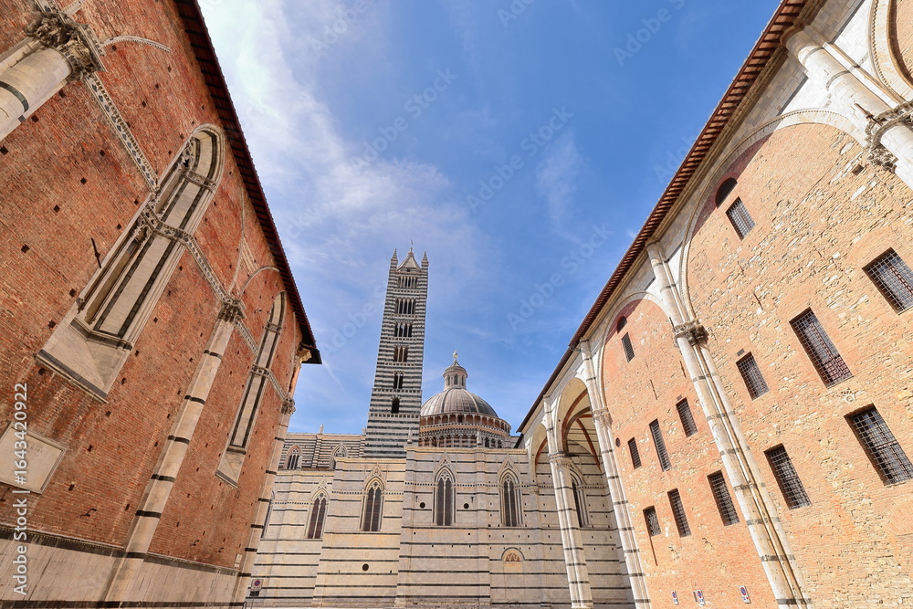 Naklejka premium Northwestward view from Piazza Jacopo della Quercia Square to the Duomo or Cathedral bell tower, dome and right semitransept. Siena-Tuscany-Italy-192