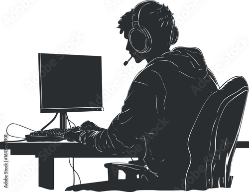 Silhouette of a young male gamer wearing headset playing video games on a computer at a desk