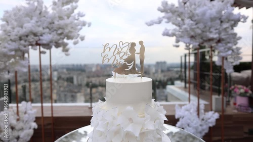 large white wedding cake with figures of the bride and groom on it