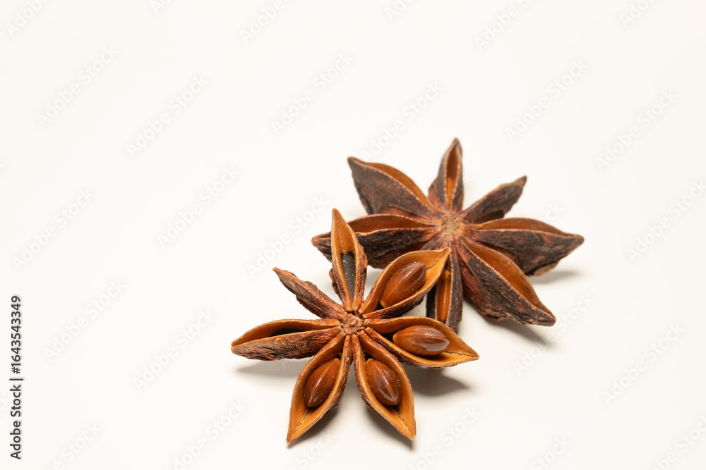 Two whole star anise pods on a white background, aromatic spice used in cooking and baking, known for its distinctive star shape Two whole star anise pods on a white background, aromatic spice used in cooking and baking, known for its distinctive star shape