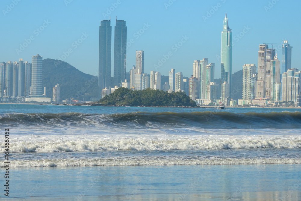 Naklejka premium Surfing in the heart of Brazil’s luxury coast – where ocean waves meet a stunning skyline.