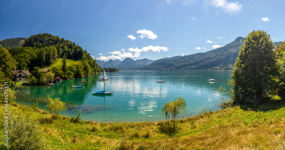 Naklejka premium Lake Wolfgangsee with sailing boats, sailboat anchored in a calm lake bay, Alps, Austria