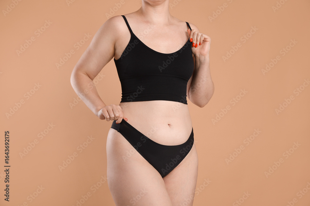 Obraz premium Liposuction. Woman in underwear on beige background, closeup
