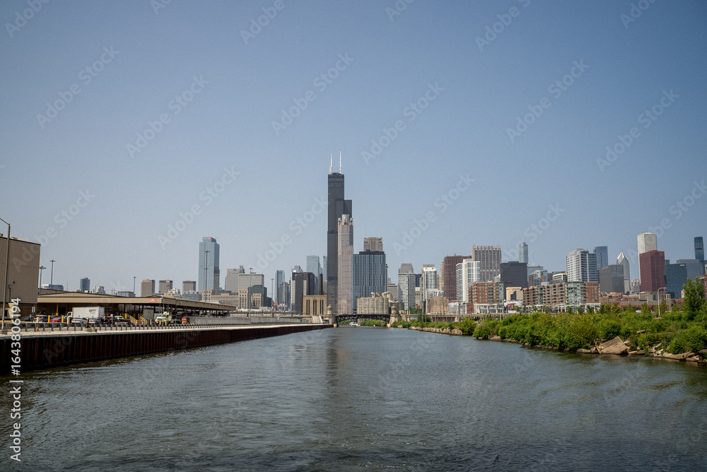 Naklejka premium Skyline view of Chicago along the river on a bright sunny day with clear blue skies and reflections on the water