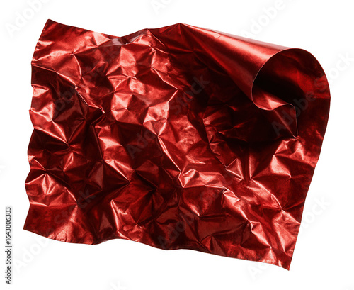 Crumpled red metallic foil with curled edge reflecting light.