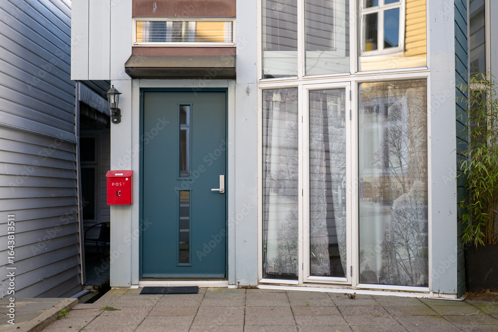 Fototapeta premium Doorway to a contemporary residential building featuring stylish design and a red mailbox in an urban setting