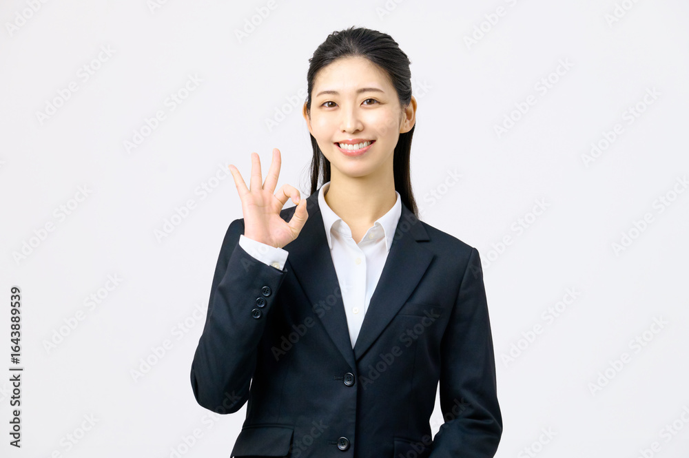 OKサインをする若いスーツの女性　ビジネス