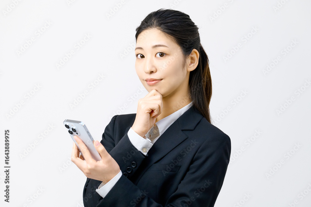 スマートフォンを持ち考えるビジネスウーマン