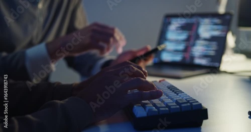 Closeup team adult male engineer collaborate on robotic hand project use AI code solutions machine learn at tech workspace night. Artificial intelligence interface collaboration prototype development.