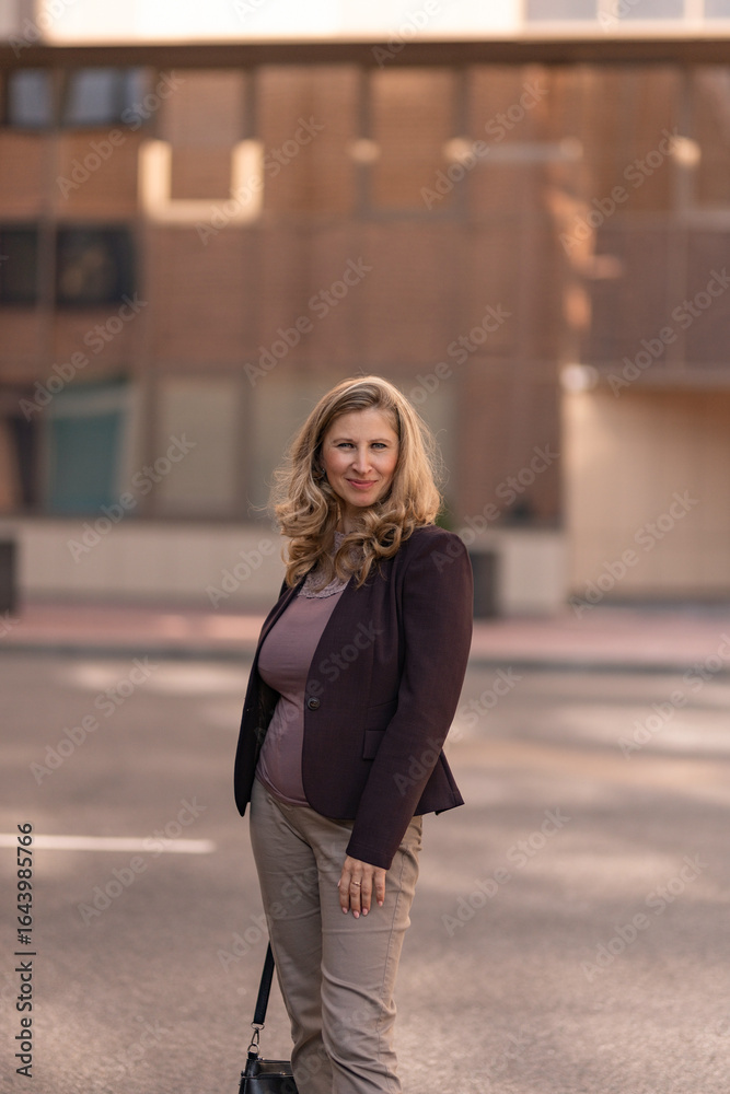 Fototapeta premium Portrait of a beautiful young blonde girl in a city park.