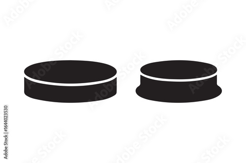 Two black hockey pucks on a white background