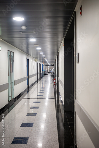 A bright and sterile hallway inside a contemporary medical facility, with doors leading to examination rooms. This image is a perfect background for healthcare, medicine, and architectural concepts.	