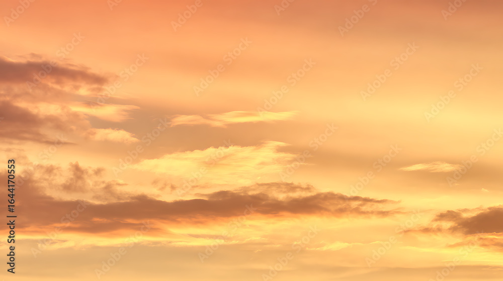 Fototapeta premium Golden sky with scattered clouds at sunset orange