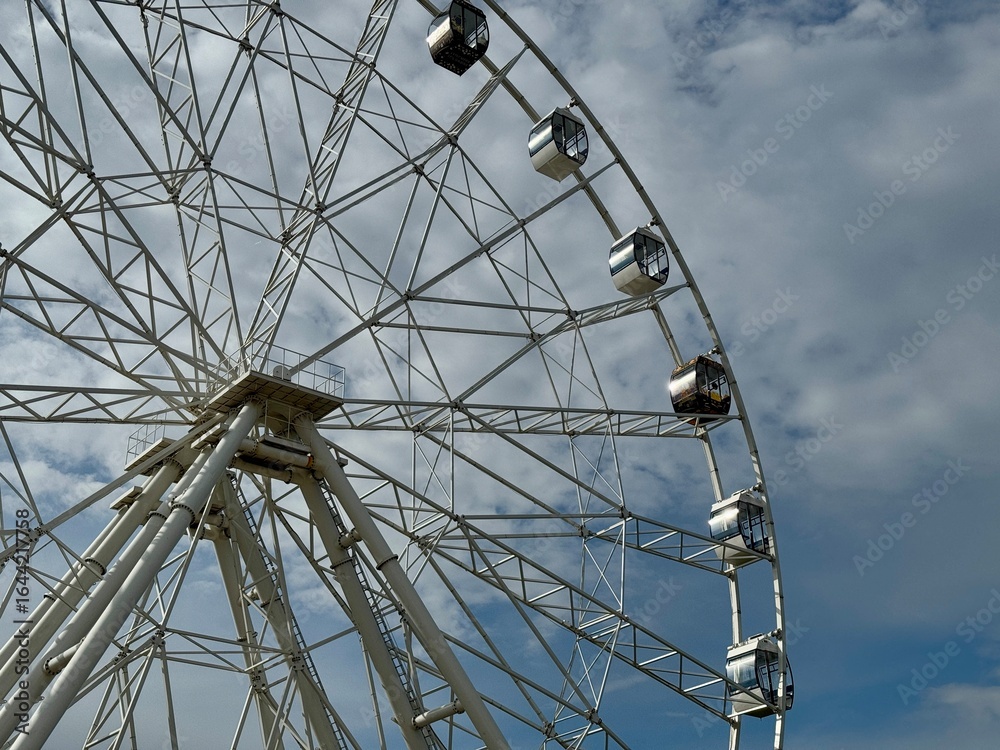 Obraz premium Ferris wheel on the background of blue sky in summer. High quality photo