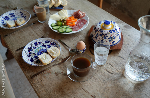 Breakfast table with food and coffee, water and bread