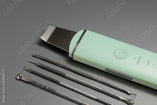 Ultrasonic facial cleansing tools. Skin care kit for cosmetologist on gray background