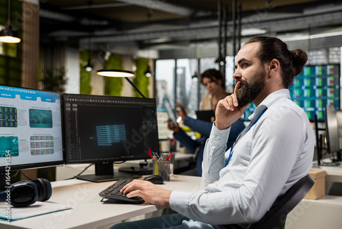 Tableau sur toile IT engineer reviewing data analysis results with artificial intelligence, integrating machine learning and automation tools to enhance productivity with dual monitors in the office