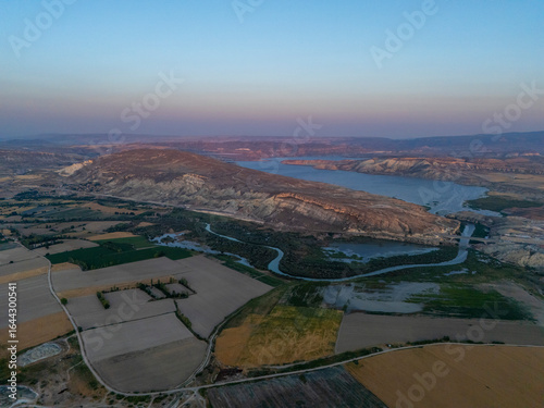 Nallihan in Ankara, Turkey, seen from above during sunset, with a winding river, cultivated farmlands, and mountains glowing in warm light, offering a peaceful and scenic natural landscape.
