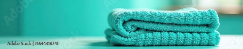 Bright teal cotton kitchen towels, neatly folded , vibrant, domestic