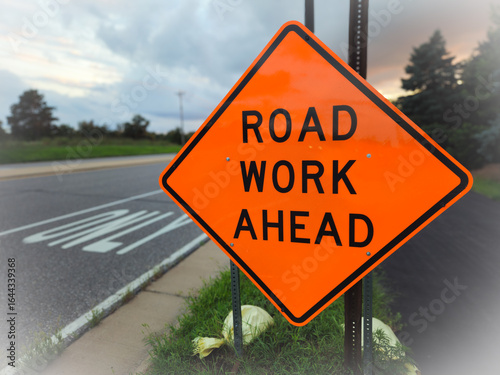 A road work ahead sign against a trail and street backdrop, for warning or informational purpose. message or communication design element with copy space. abstract improvement concept